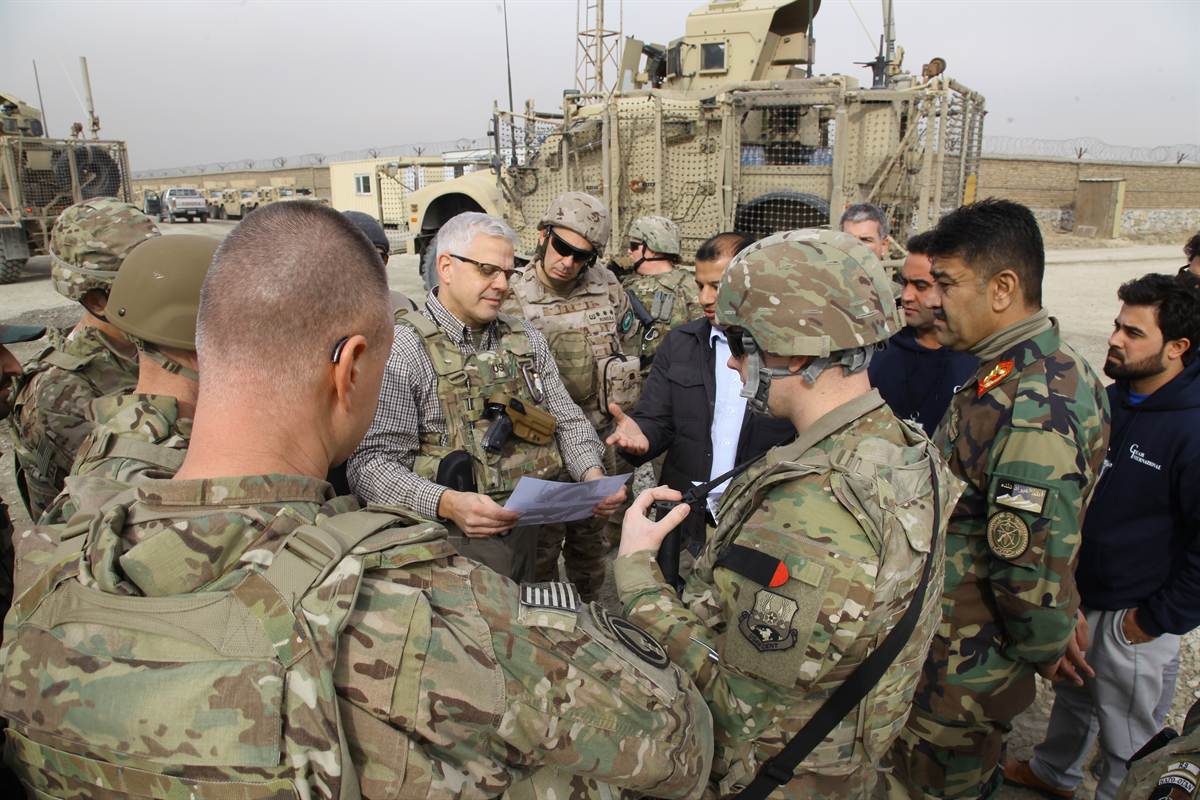 Synerje staff reviewing delivery and acceptance documents with U.S. government representatives beside delivered vehicles