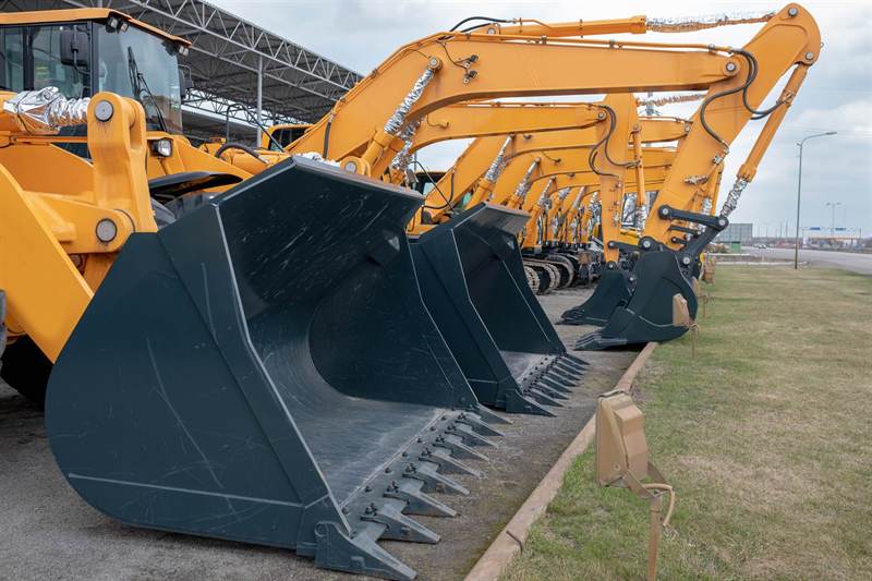 Row of new excavators and wheel loaders staged for procurement